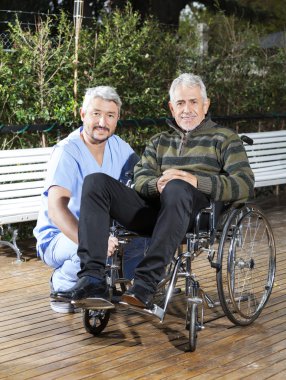 Tekerlekli sandalye Lawn üst düzey adam çömelmiş fizyoterapist