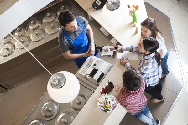 Frau steht bei Familie und bezahlt mit nfc-Technologie — Stockfoto