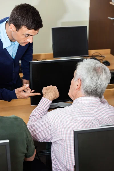 Tutor di discussione con l'uomo anziano in classe di computer — Foto Stock