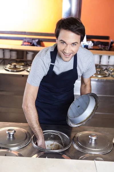 Camarero eliminando el helado del contenedor en el salón —  Fotos de Stock