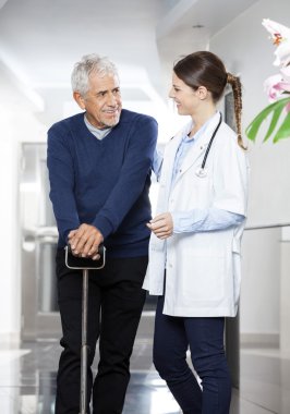 Hasta erkek doktorda bakarken baston kullanarak