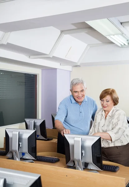 Personas mayores felices usando la computadora en el aula — Foto de Stock