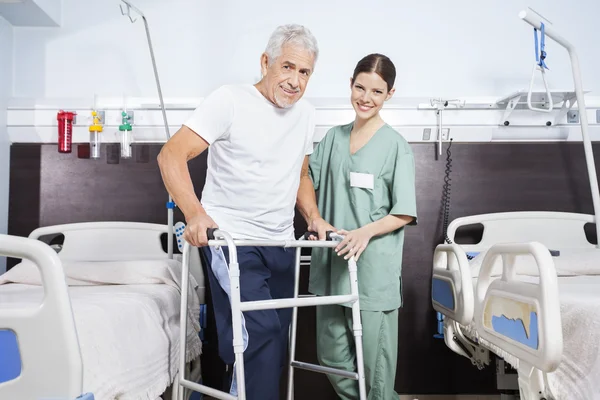 Enfermera con un hombre mayor usando Walker en el centro de rehabilitación —  Fotos de Stock