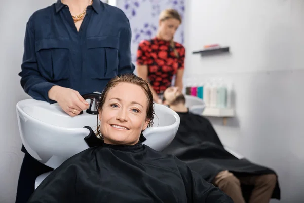 Feliz mujer consiguiendo pelo lavado en salón —  Fotos de Stock