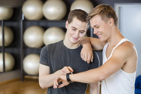 Gli amici maschi controllano il pedometro in palestra — Foto Stock