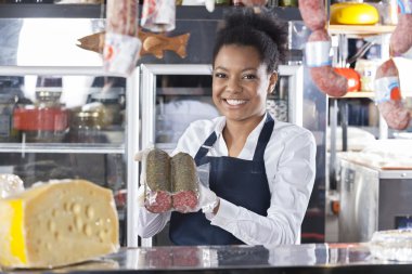 Mutlu genç pazarlamacı peynir dükkanında gösterilen