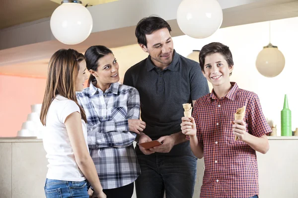 Ragazzo holding coni da famiglia in gelato Parlor — Foto Stock