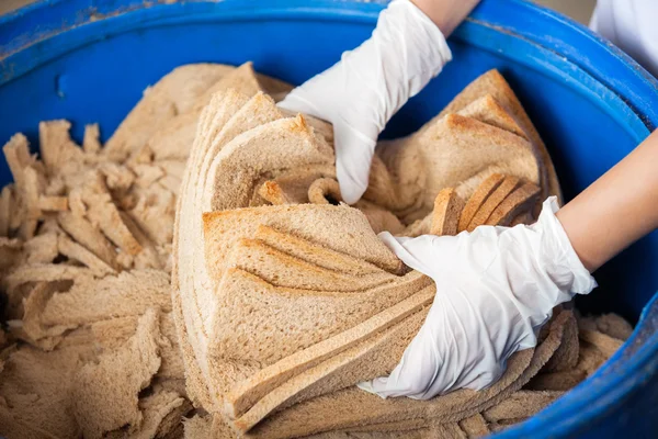 Αρτοποιοί χέρια απόρριψη αποβλήτων ψωμιού σε κάδο απορριμμάτων — Φωτογραφία Αρχείου