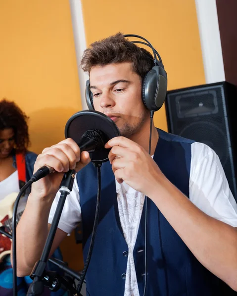 Homem cantando enquanto segurando microfone — Fotografia de Stock