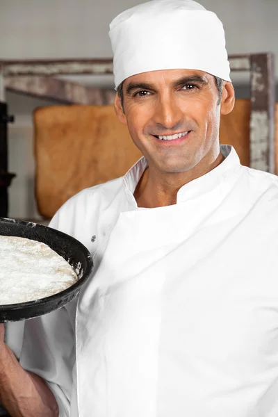 Säker manliga bagare hålla degen fack på bageriet — Stockfoto