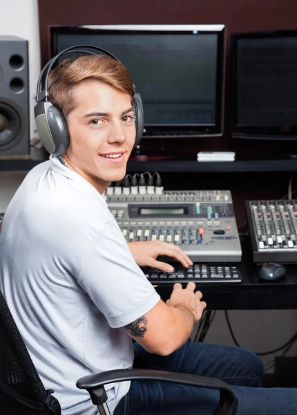 若い男がレコーディング スタジオでオーディオをミキシング笑顔 — ストック写真