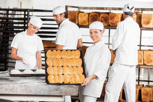 Padeiro confiante mostrando pães cozidos na padaria — Fotografia de Stock