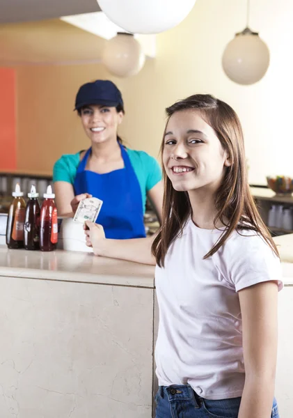 Sorridente ragazza dando nota a cameriera in gelateria — Foto Stock