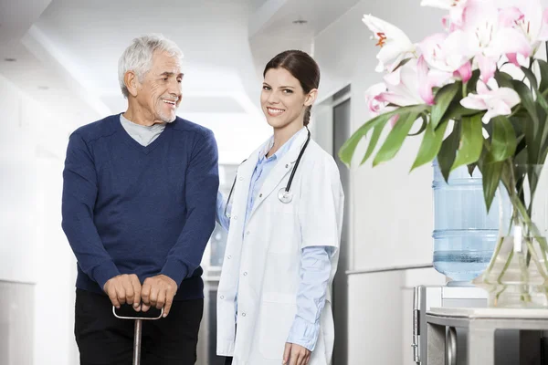 Médico feminino confiante em pé com o homem sênior — Fotografia de Stock