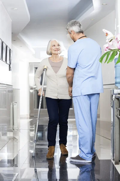 Physiotherapist Helping Senior Patient With Crutches — Stock Photo, Image