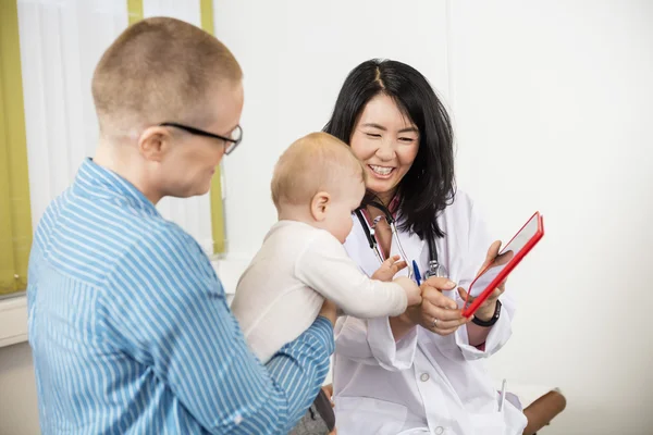 幼児を持つ女性に女性医師を示すデジタル タブレット — ストック写真