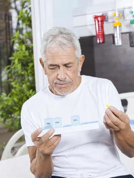 Мужчина держит таблетки и контейнер для пациентов — стоковое фото
