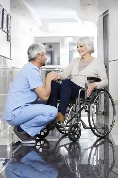 Fyzioterapeut, drží za ruku starší pacienti na vozíku — Stock fotografie
