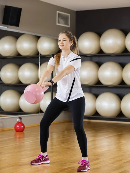 Αποφασισμένη γυναίκα άρση Kettlebell στο κέντρο ευεξίας — Φωτογραφία Αρχείου