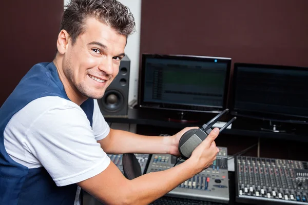 Portrait Of Young Man Holding Headphones At Mixing Table — Stock Photo, Image