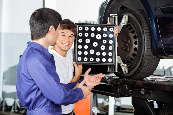 Meccanico con collega durante l'utilizzo di Wheel Aligner — Foto Stock