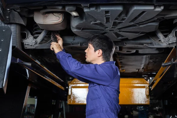 Mechanic Examining Underneath Lifted Car — Stock Photo, Image