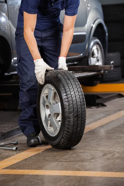 Meccanico Holding auto pneumatico al garage — Foto Stock