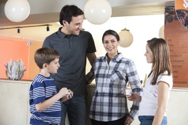 Gülümseyen kadın aile içinde dondurma salonu ile ayakta