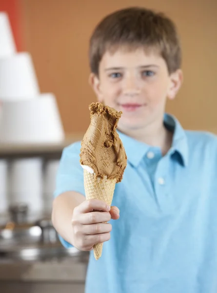 Rapaz bonito segurando sorvete de chocolate — Fotografia de Stock