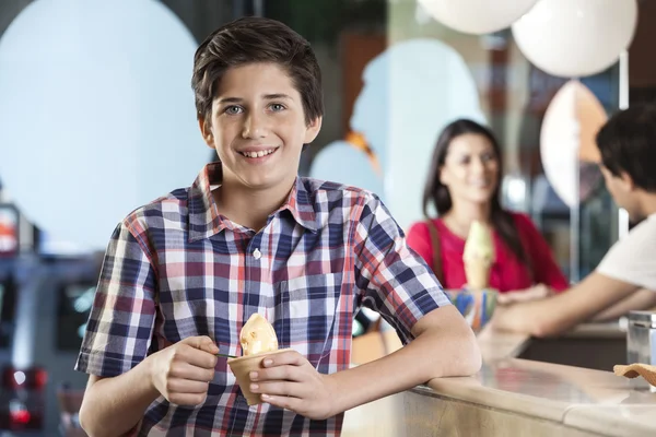 パーラーでアイスクリームを持って微笑む少年 — ストック写真