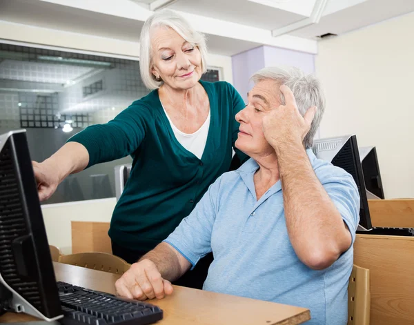 Vrouw die mannelijke klasgenoot Computer klasse — Stockfoto