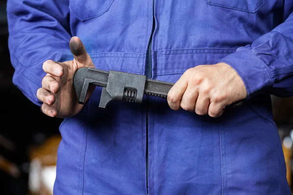 Mechanic Holding Wrench In Repair Shop