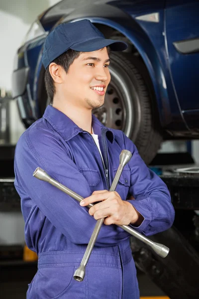 Thoughtful Mechanic Holding Rim Wrench At Garage — Stock Photo, Image