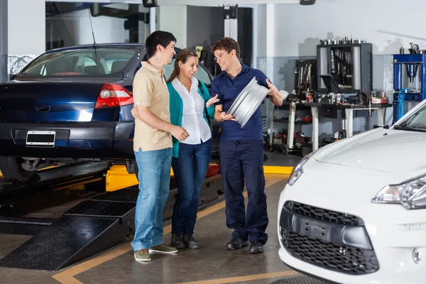 Mechaniker erklärt Paar Radkappen — Stockfoto