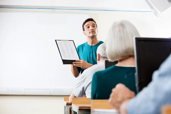 Leraar geeft lessen aan Senior mensen In berekenen Lab — Stockfoto