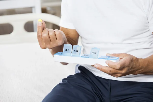 Midsection de homem sênior segurando pílula e recipiente — Fotografia de Stock