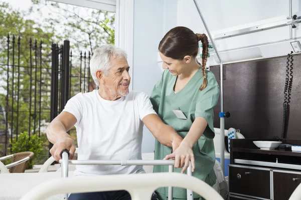 Smiling Man Being Assisted By Female Nurse In Using Walker — Stock Photo, Image