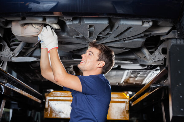 Mechanic Repairing Underneath Car With Wrench