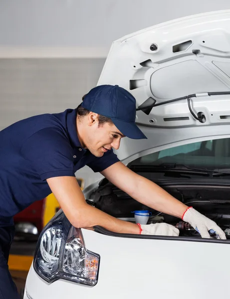 Mechaniker begutachtet Auto-Motor in Werkstatt — Stockfoto