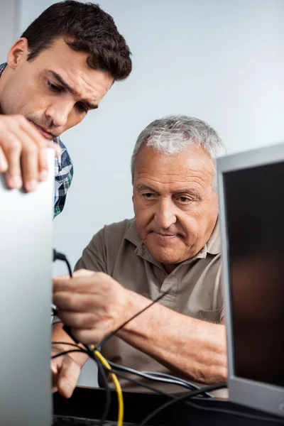 Enseignant Regarder un homme âgé installer un ordinateur — Photo