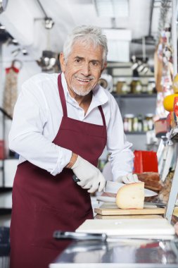 Mutlu satıcı peynir dükkanında Dilimleme