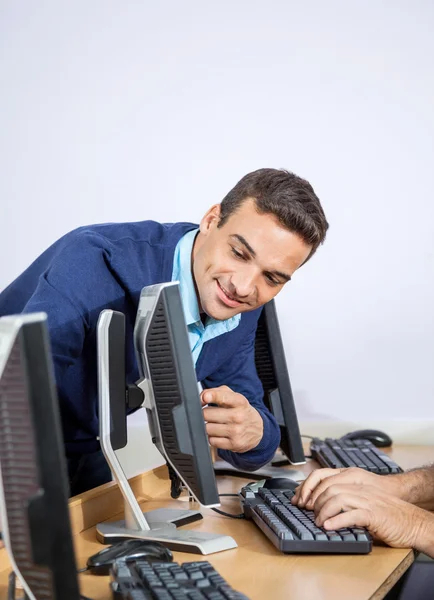 Professor mostrando algo ao homem sênior no computador na sala de aula — Fotografia de Stock