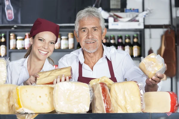 Glada medarbetare säljer färsk ost i butik — Stockfoto