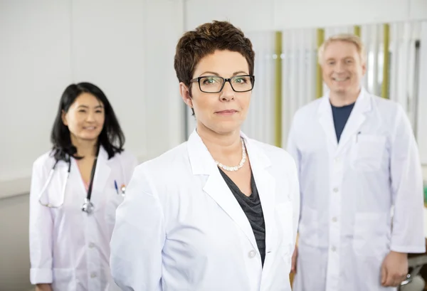 Confident Female Doctor Standing With Colleagues In Hospital — Stock Photo, Image