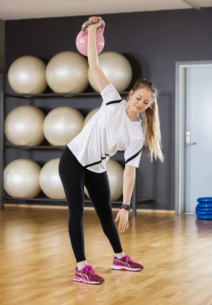 Mulher se exercitando ao levantar Kettlebell no ginásio — Fotografia de Stock