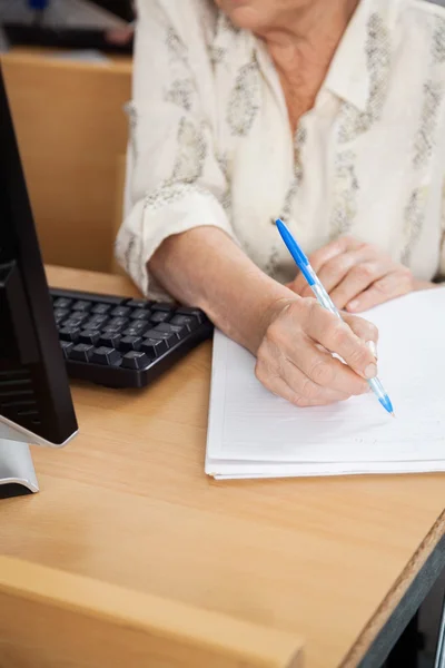 Oberschüler schreibt Notizen im Computerkurs — Stockfoto