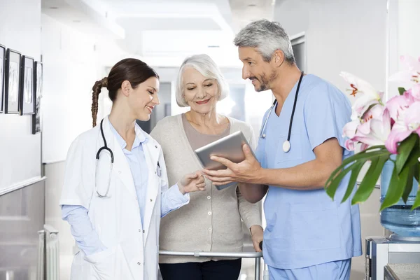 Sjukgymnast visar rapporter att Patient och läkare på Tablet PC — Stockfoto