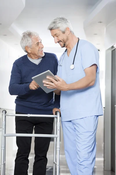 Physiotherapeutin zeigt Senioren Berichte über digitales Tablet — Stockfoto