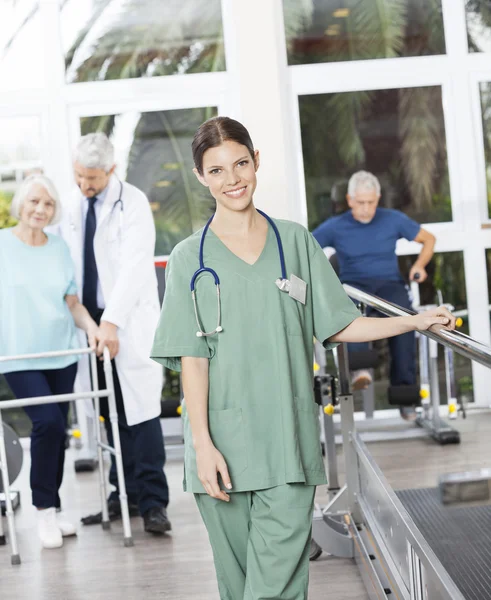 Vertrouwen vrouwelijke fysiotherapeut permanent In Fitness Center — Stockfoto