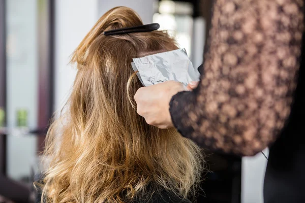 Kosmetolog att sätta omkullkastar i kvinnliga klienter hår — Stockfoto